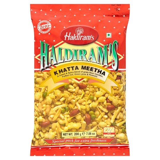 Haldiram's Khatta Meetha kombinerer krydrede linser, peanøtter, risflak og andre deilige ingredienser i en uimotståelig blanding av syrlige og søte smaker.